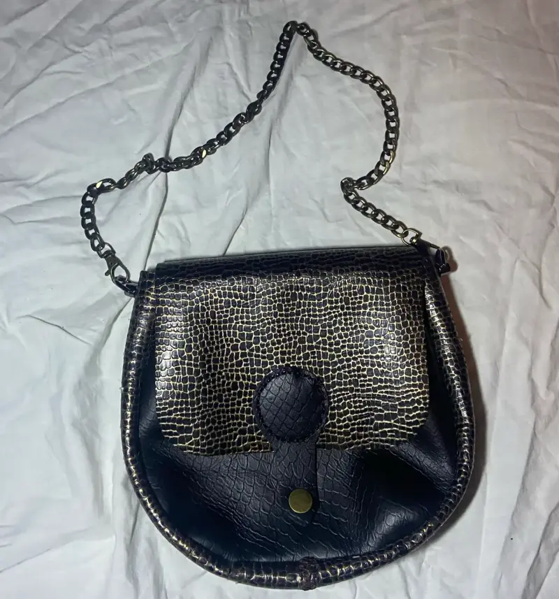 Cartera de cuero con diseño reptil y cadena