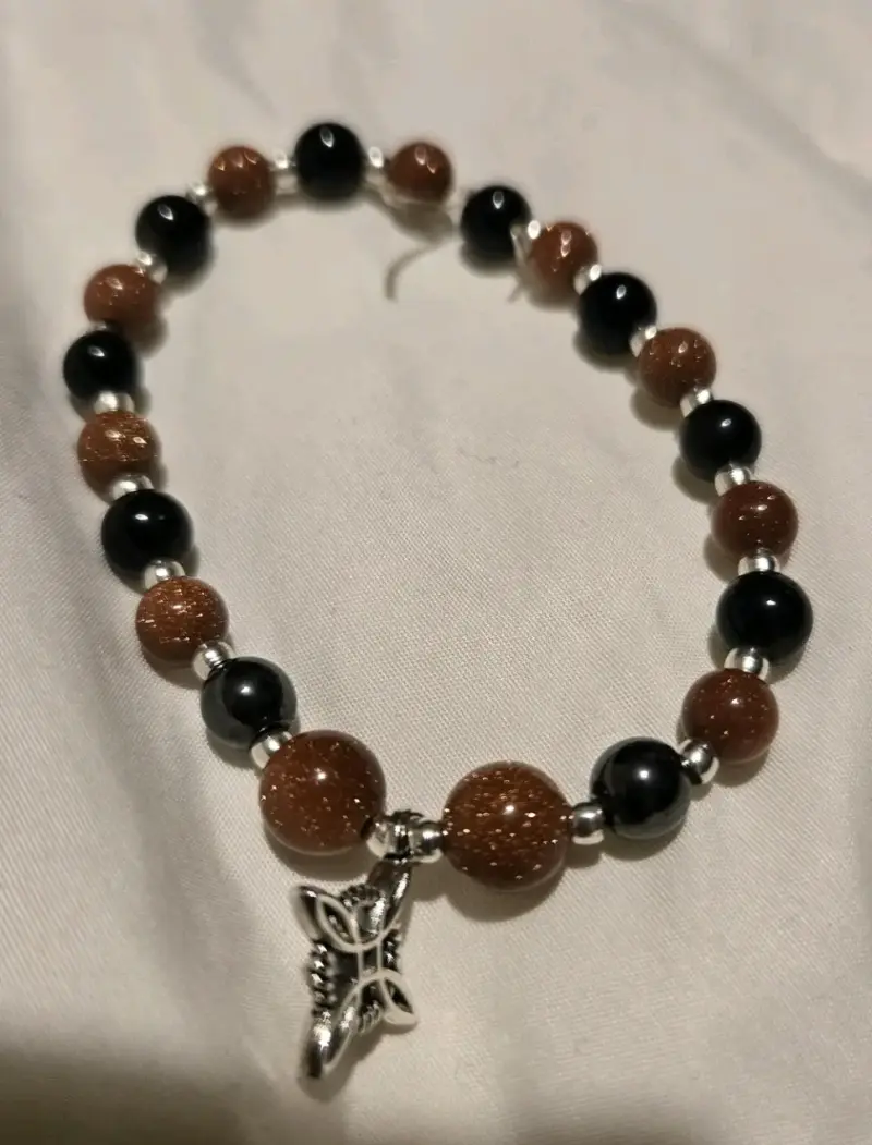 Pulsera de piedras con dije de nudo de bruja