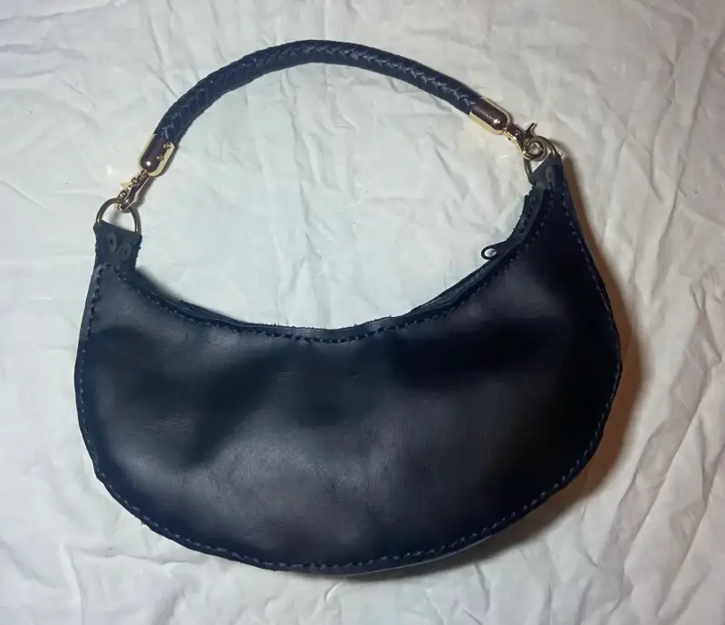 Cartera de cuero negra con asa trenzada