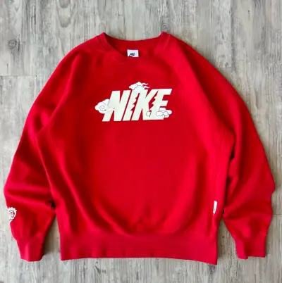 Polerón rojo Nike con diseño de nubes - miniatura 1