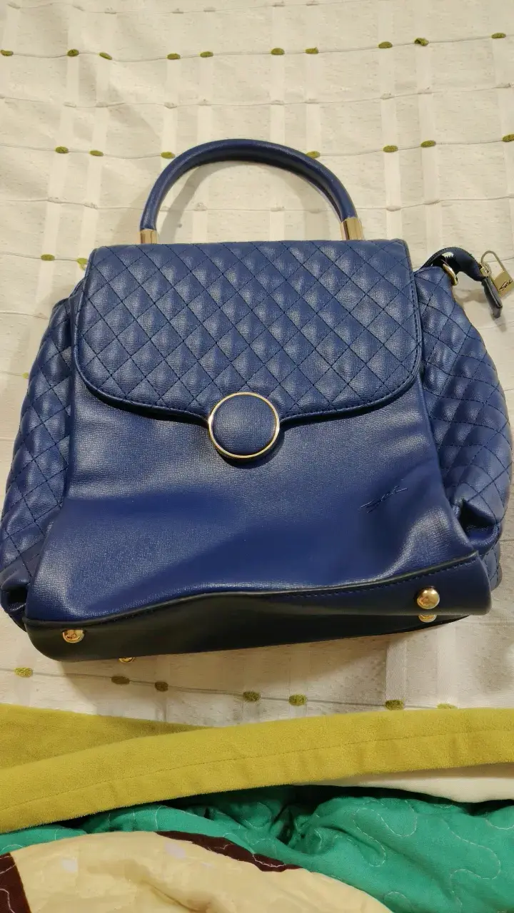 Bolso de mano azul con diseño acolchado