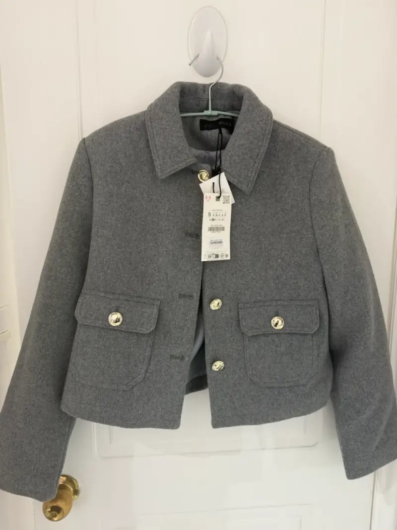Chaqueta corta gris con botones dorados