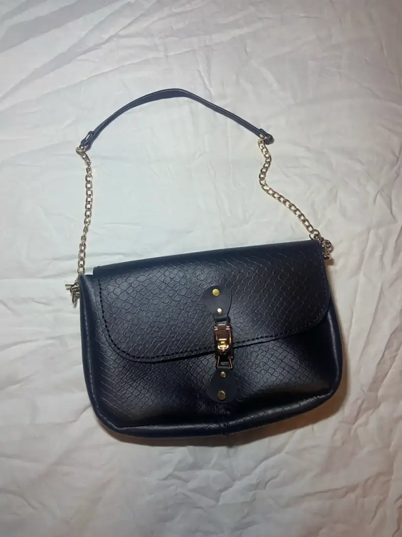 Cartera negra con cadena dorada elegante