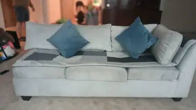 Sofá seccional gris claro con cojines azules - miniatura 1