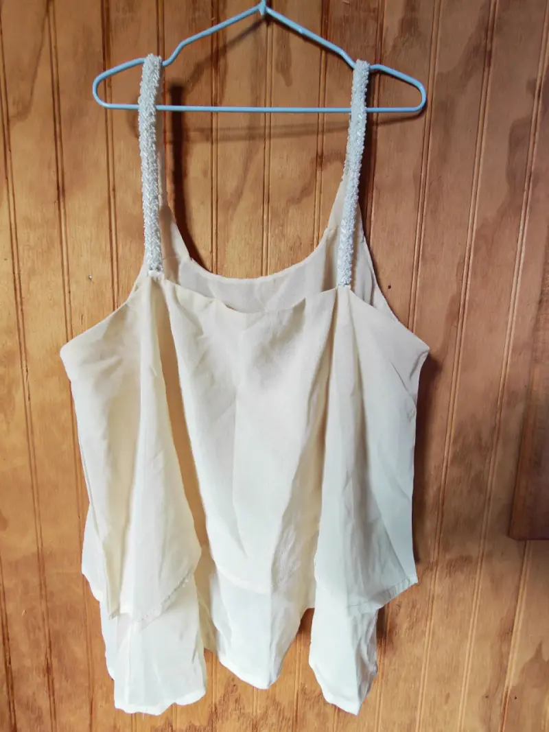 Blusa sin mangas color crema con tirantes decorativos