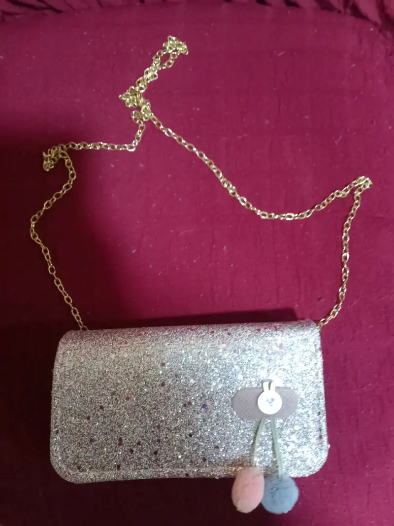 Cartera de mano brillante con cadena dorada