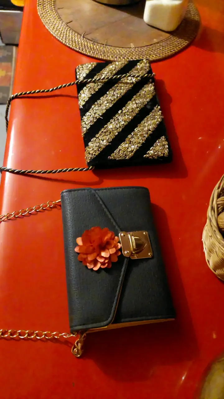 Cartera de mano negra con flor decorativa