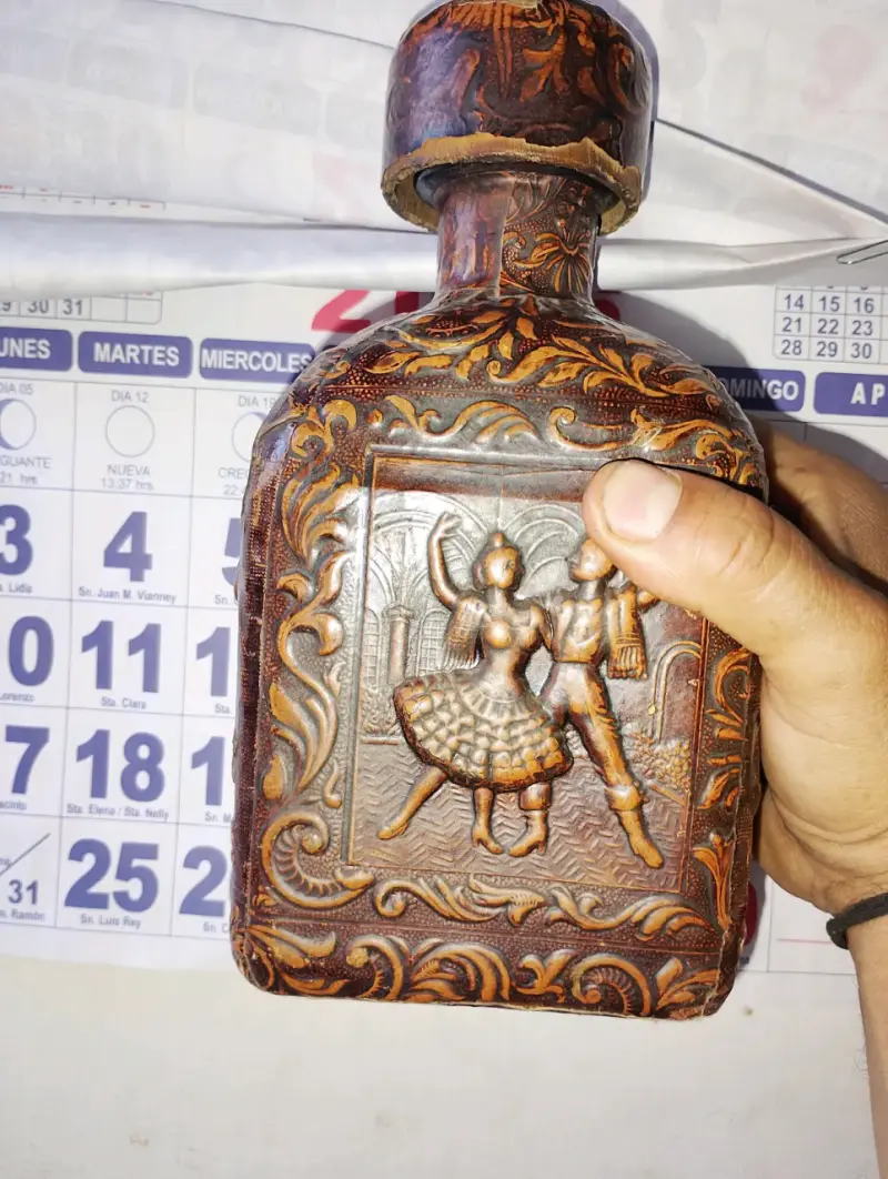 Botella decorativa de cuero tallado con diseño folclórico