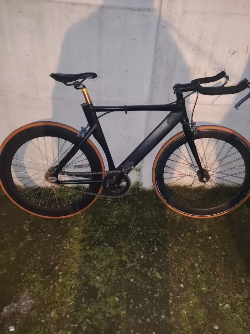 Bicicleta de ruta negra con llantas anaranjadas - 1