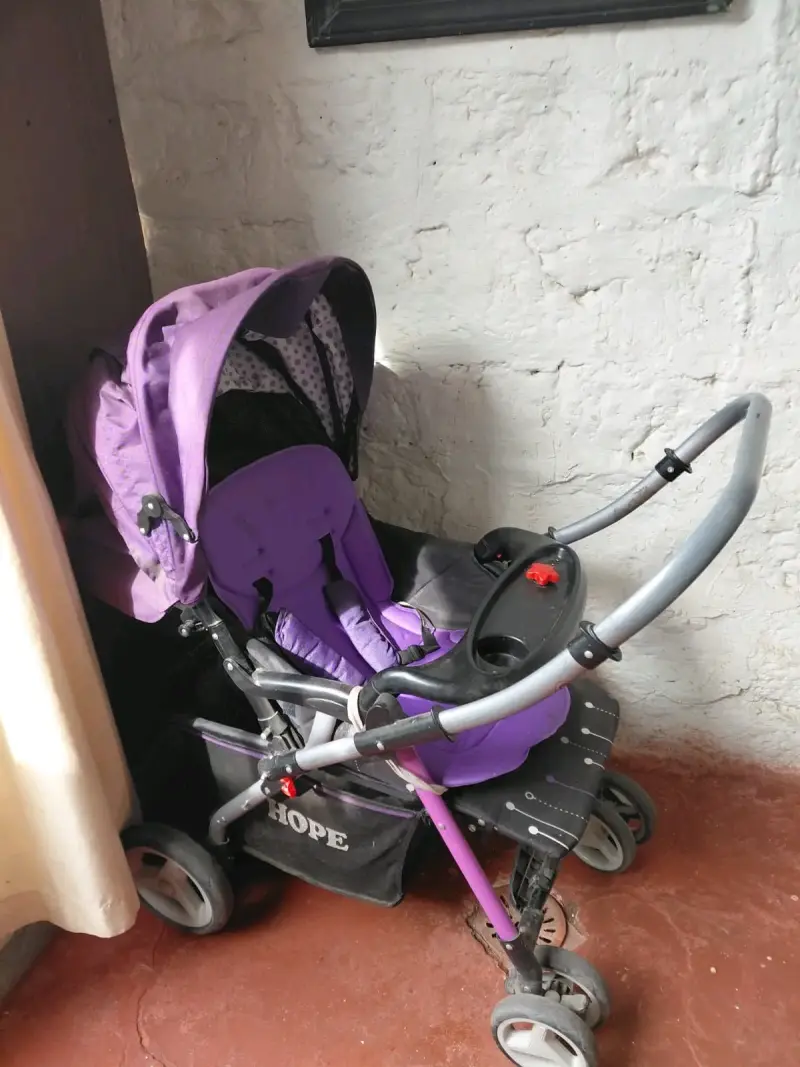 Coche de bebé morado con bandeja y canasto