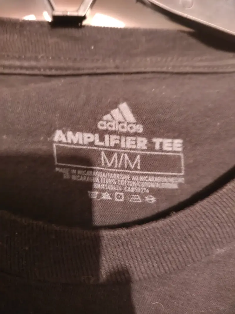 Polera negra Adidas Amplifier Tee con logo dorado - 2