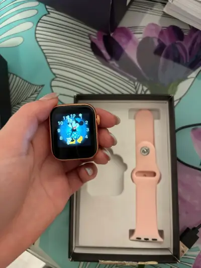 Smartwatch con correa rosa y cargador - miniatura 1