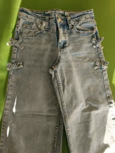 Jeans azules con lazos decorativos para mujer - miniatura 1