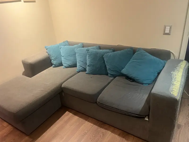 Sofá seccional gris con cojines azules