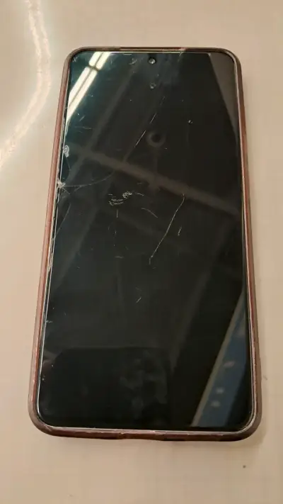Smartphone con pantalla dañada y desgaste - miniatura 2