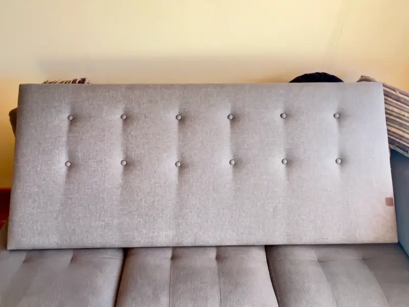 Respaldo de cama tapizado gris con botones