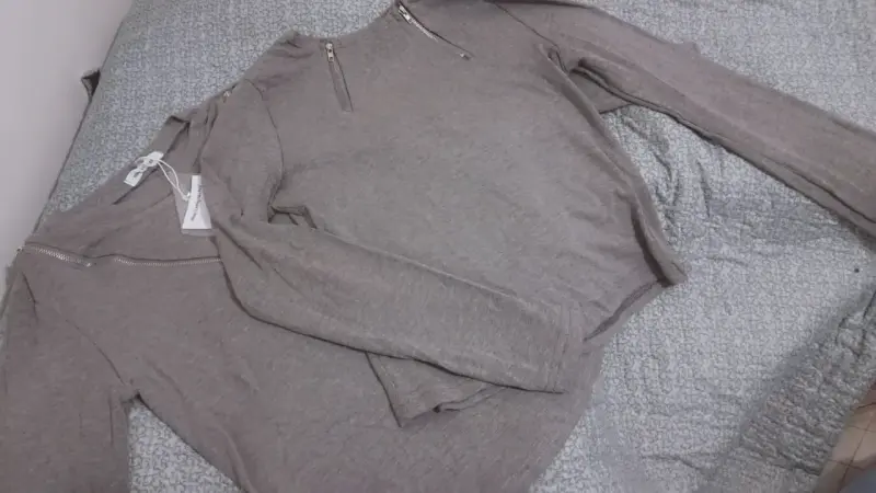 Polera manga larga gris con cierre decorativo