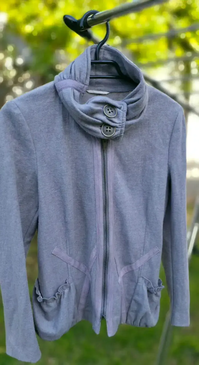 Chaqueta gris con cuello alto y botones decorativos