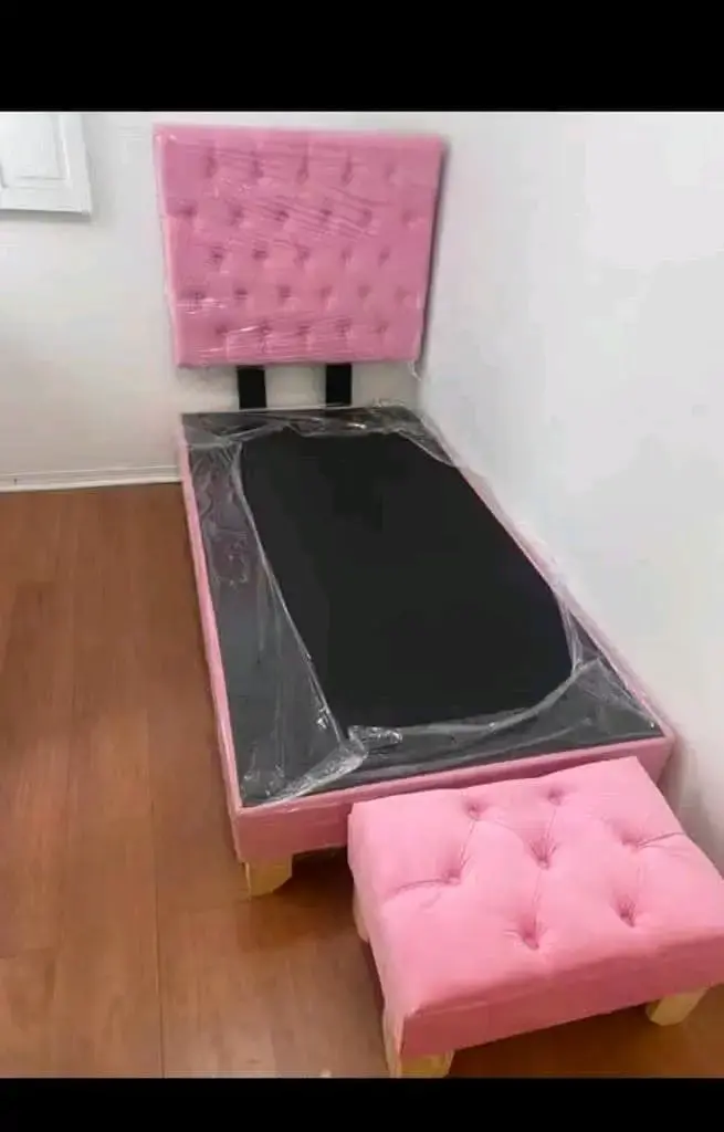 Cama individual tapizada rosa con cabecera