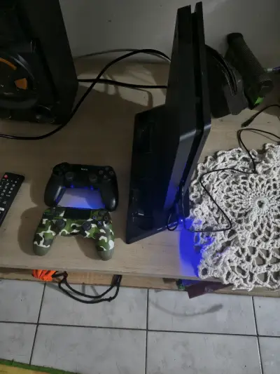 Consola PlayStation 4 con dos controles y juego - miniatura 1