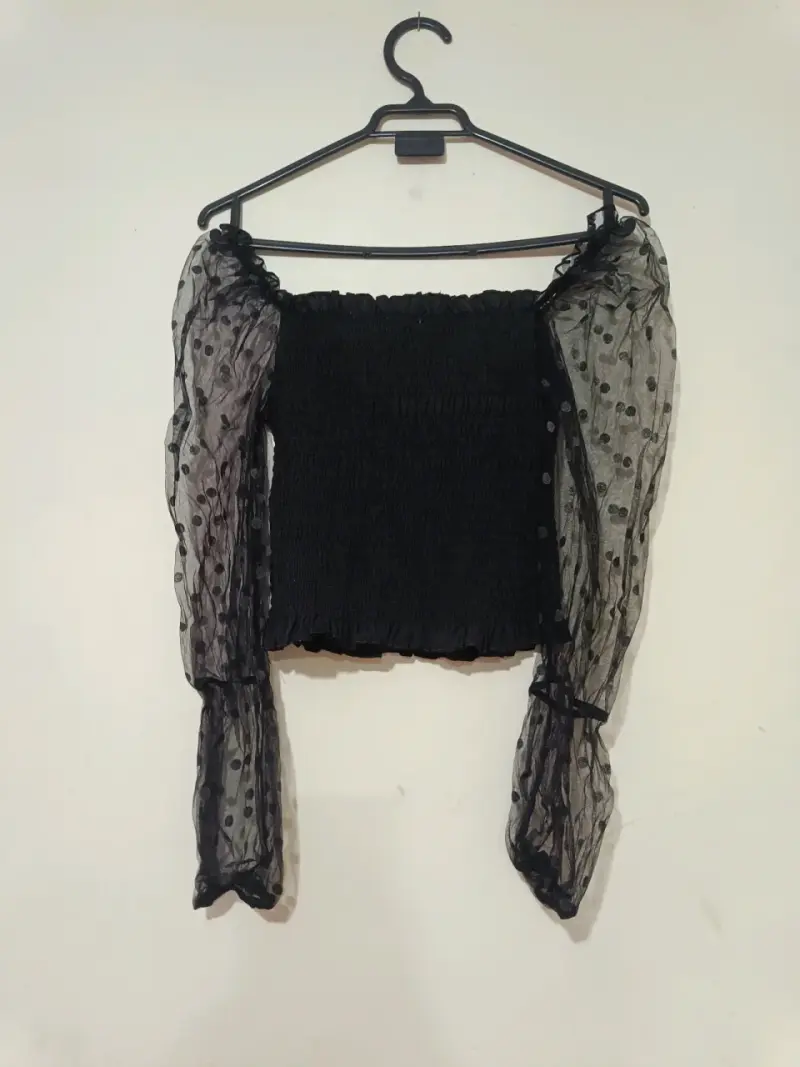 Blusa negra con mangas transparentes de lunares