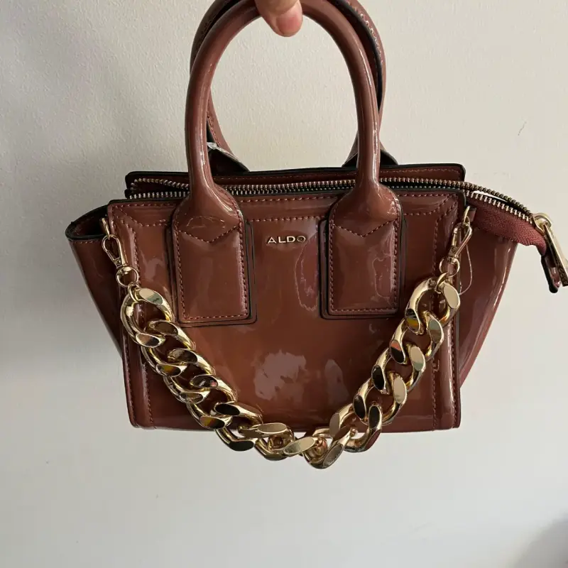 Cartera de mano marrón con cadena dorada Aldo