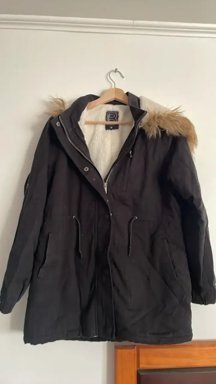 Parka negra con capucha de piel sintética