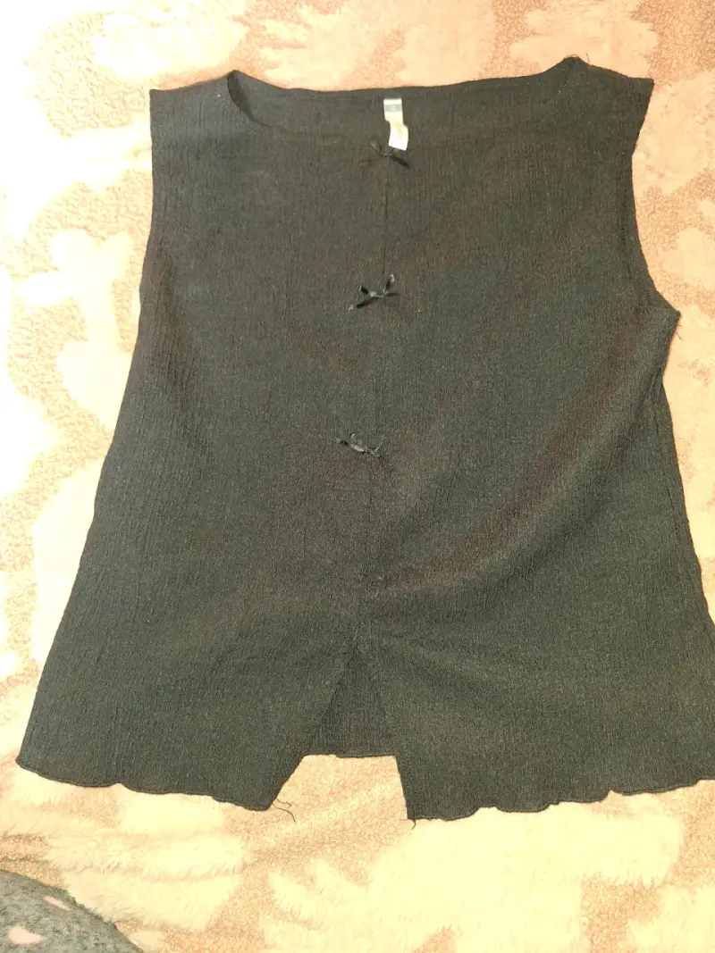 Polera negra sin mangas con lazo decorativo - 1