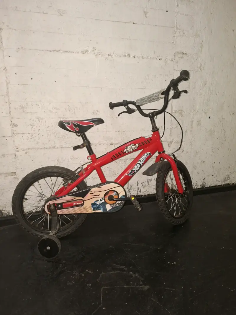 Bicicleta infantil roja con ruedas de entrenamiento