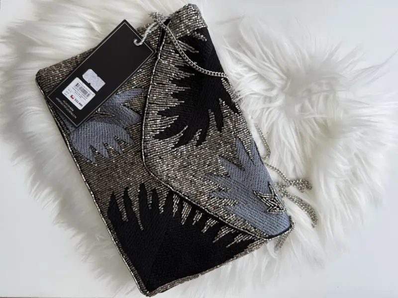 Cartera de mano con diseño de cuentas metálicas