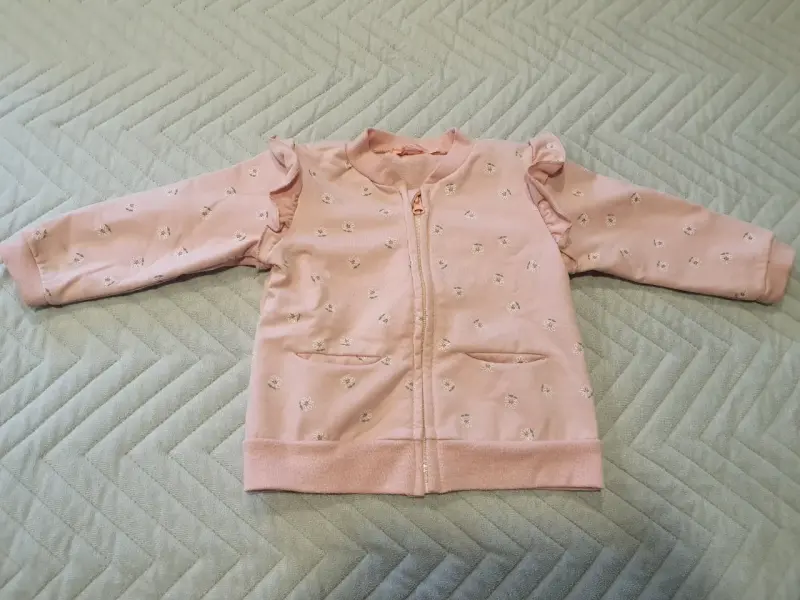 Polerón de bebé rosa con volantes y diseño floral