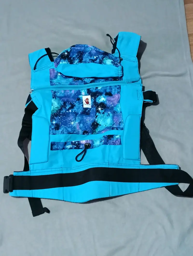 Mochila portabebé ergonómica azul con diseño espacial