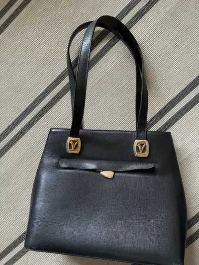 Elegante cartera de cuero negro con detalles dorados - miniatura 1
