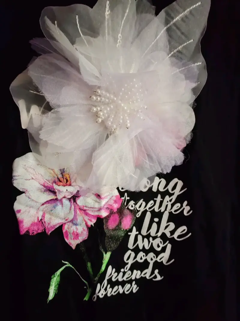 Polera negra con diseño floral y texto - 3