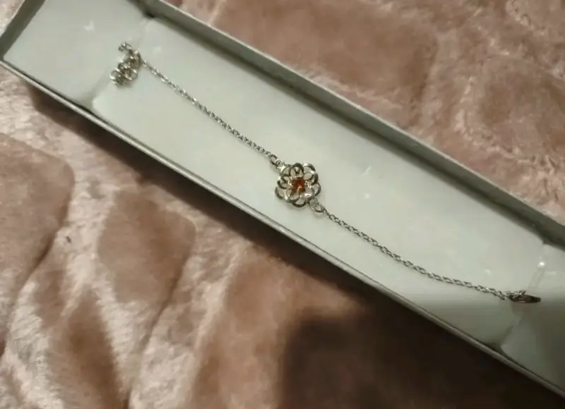 Pulsera de plata con diseño de flor y piedra roja