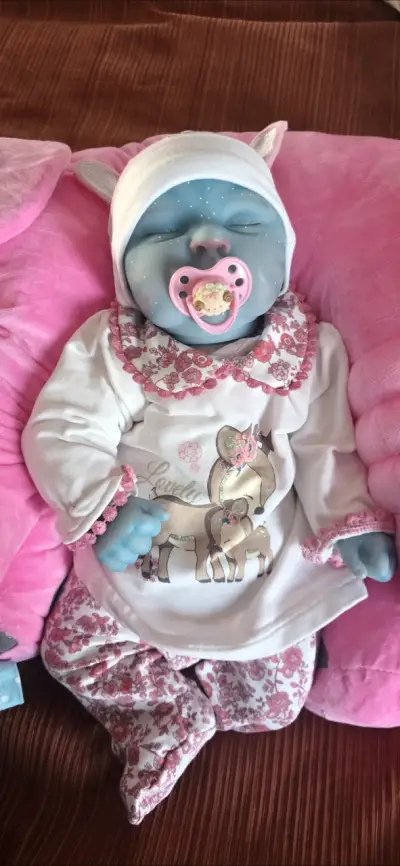 Muñeca reborn azul con ropa floral - miniatura 3
