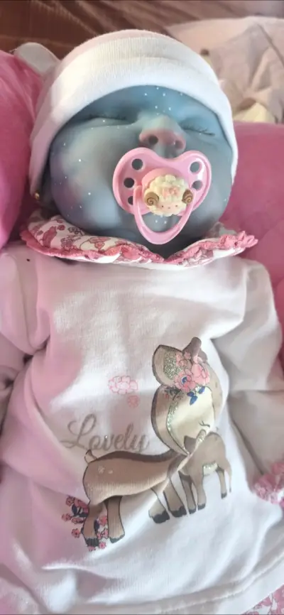 Muñeca reborn azul con ropa floral - miniatura 4