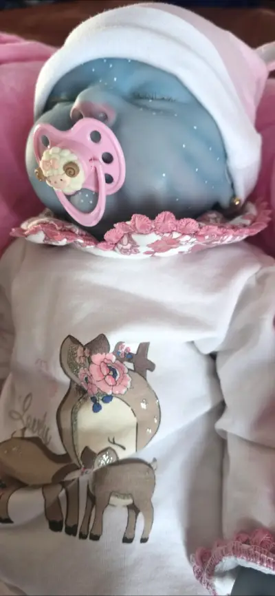 Muñeca reborn azul con ropa floral - miniatura 5