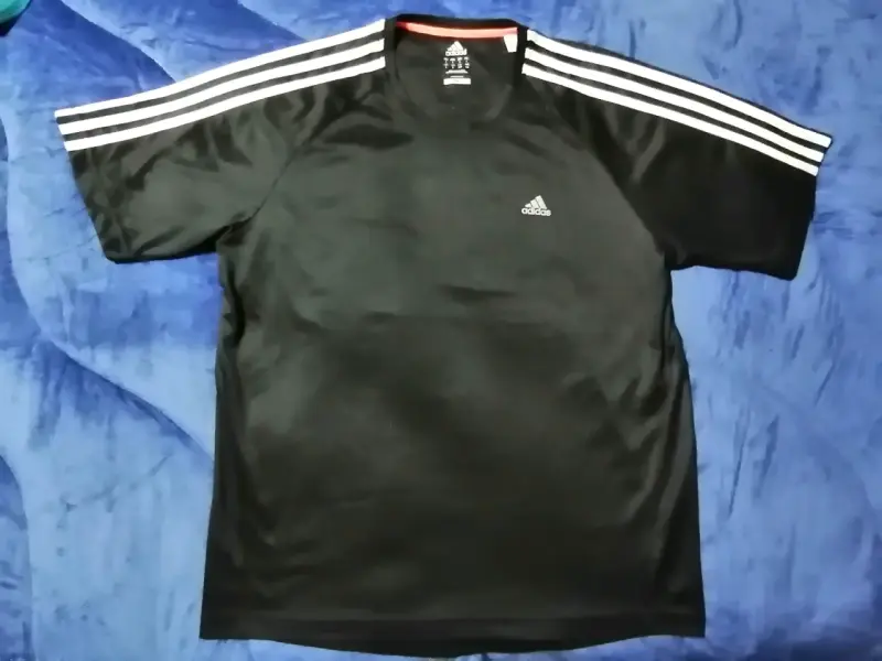 Polera deportiva negra Adidas con rayas blancas