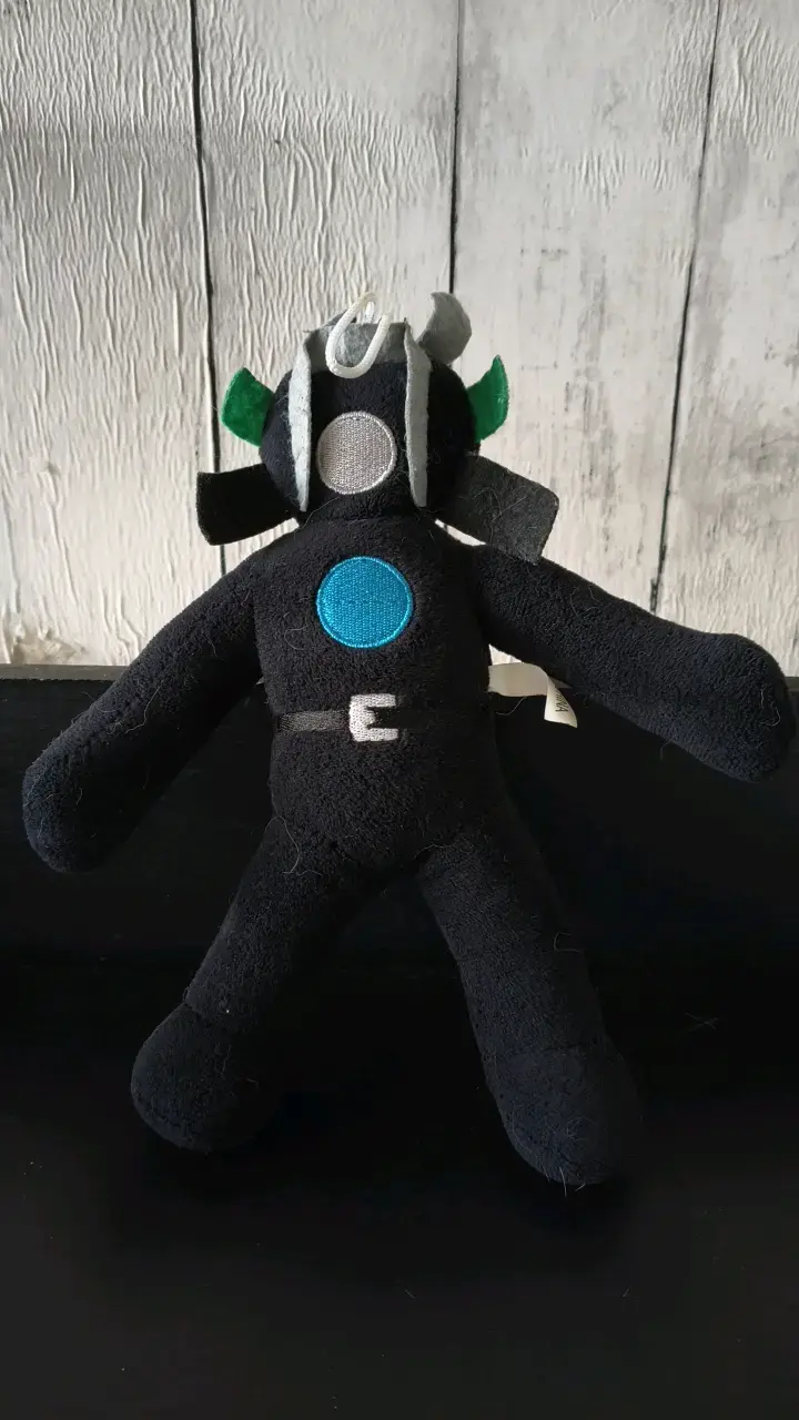 Peluche de superhéroe negro con detalles coloridos