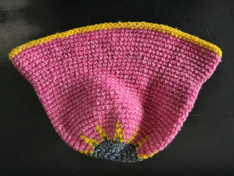 Sombrero tejido a crochet rosa con diseño floral