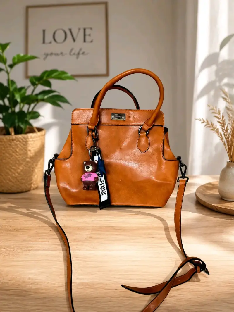 Bolso de cuero marrón con llavero decorativo
