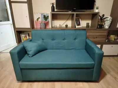 Sofá cama azul turquesa con cojín - miniatura 1
