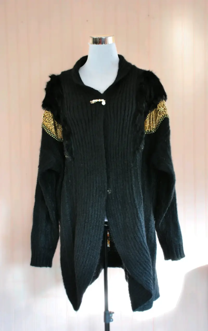 Cardigan negro con detalles dorados y broche