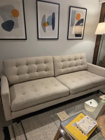 Sofá beige de tres plazas con diseño moderno - miniatura 1