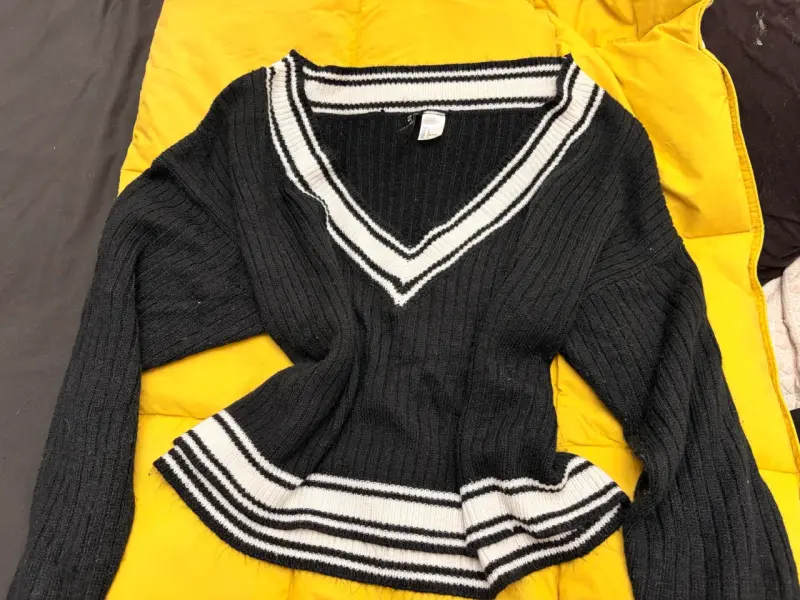 Suéter negro con cuello en V y rayas blancas - 1