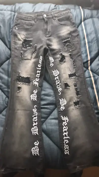 Jeans negros con diseño rasgado y texto - miniatura 1