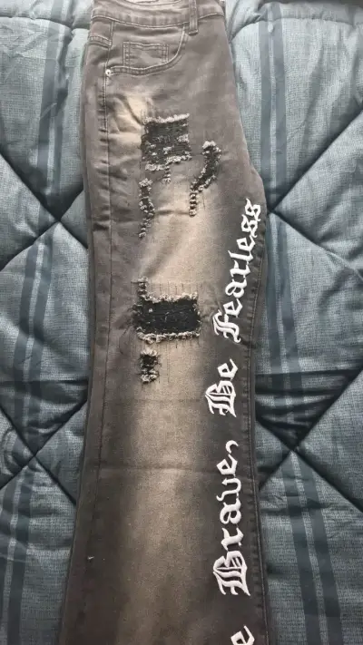 Jeans negros con diseño rasgado y texto - miniatura 3