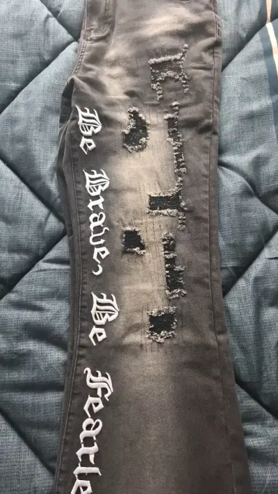 Jeans negros con diseño rasgado y texto - miniatura 4