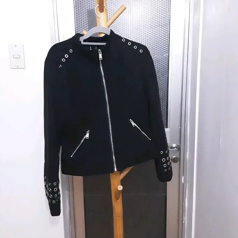 Chaqueta negra con ojales metálicos
